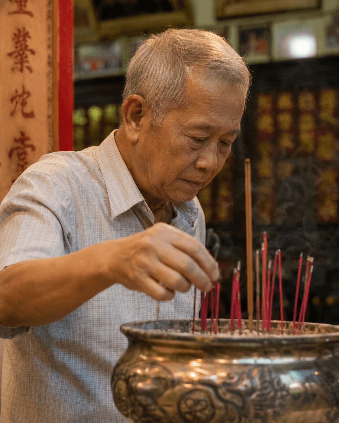 A long-serving member tending the incense pot